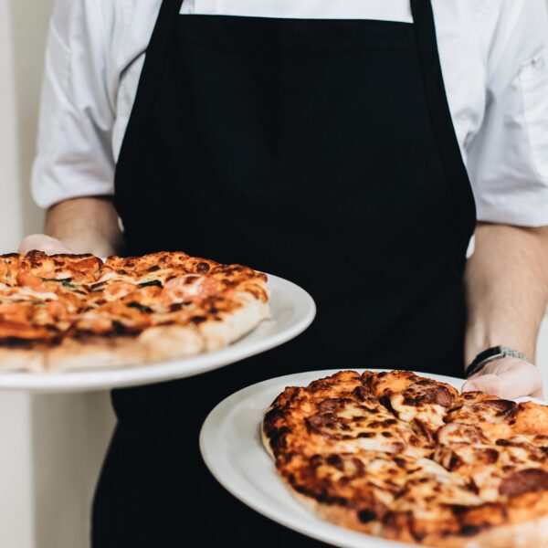 Waiter holding two pizzas